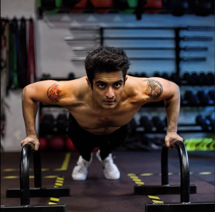 An Om Tattoo on his Right Shoulder and A lion Face tattoo on his Left Shoulder