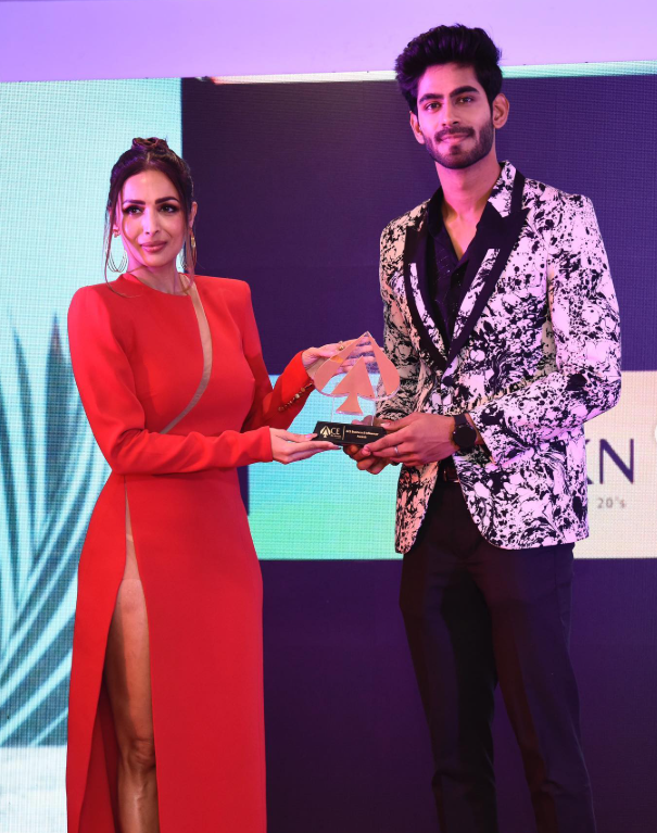 Rishabh Jaiswal receiving the awards from Malaika Arora